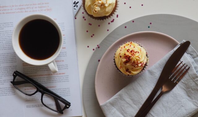 coffee, cup, drink, breakfast, food, chocolate, sweet, table, sugar, espresso, spoon, plate, tea, hot, mug, saucer, coffee cup, glasses, desktop, table top, cupcake, cake, icing, dessert, table wear, magazine, read, cafe, caffeine, cappuccino, white, black, beverage, tea cup, morning